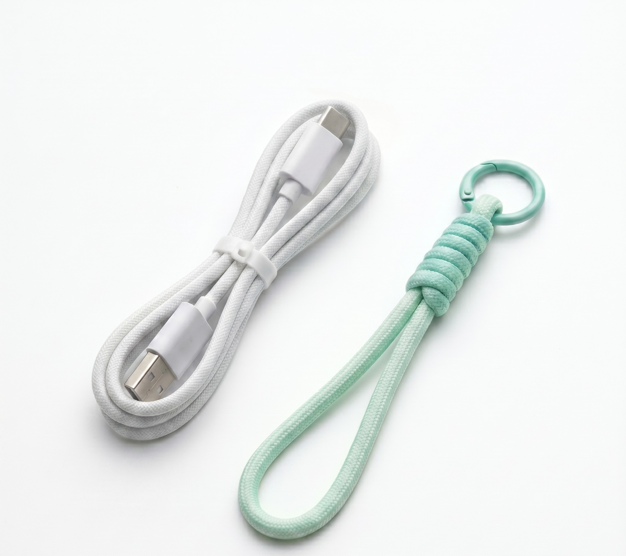 White braided USB charging cable and mint green rope keychain accessory